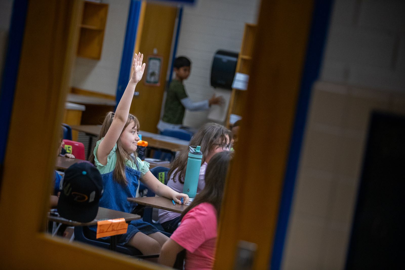 A Booth-Fickett student eagerly raises her hand during the first week of school.