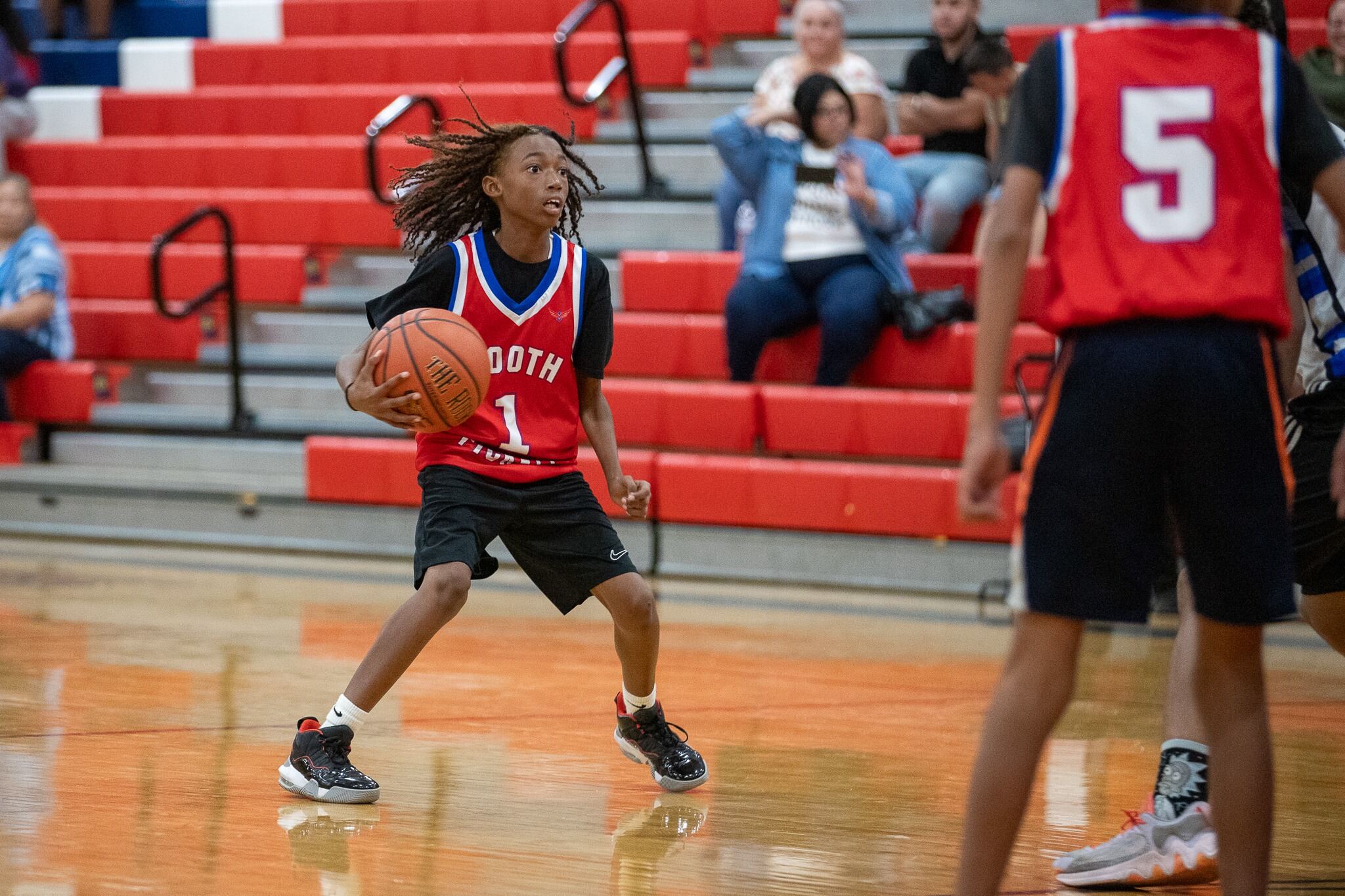 A boy holds a basketball on the court