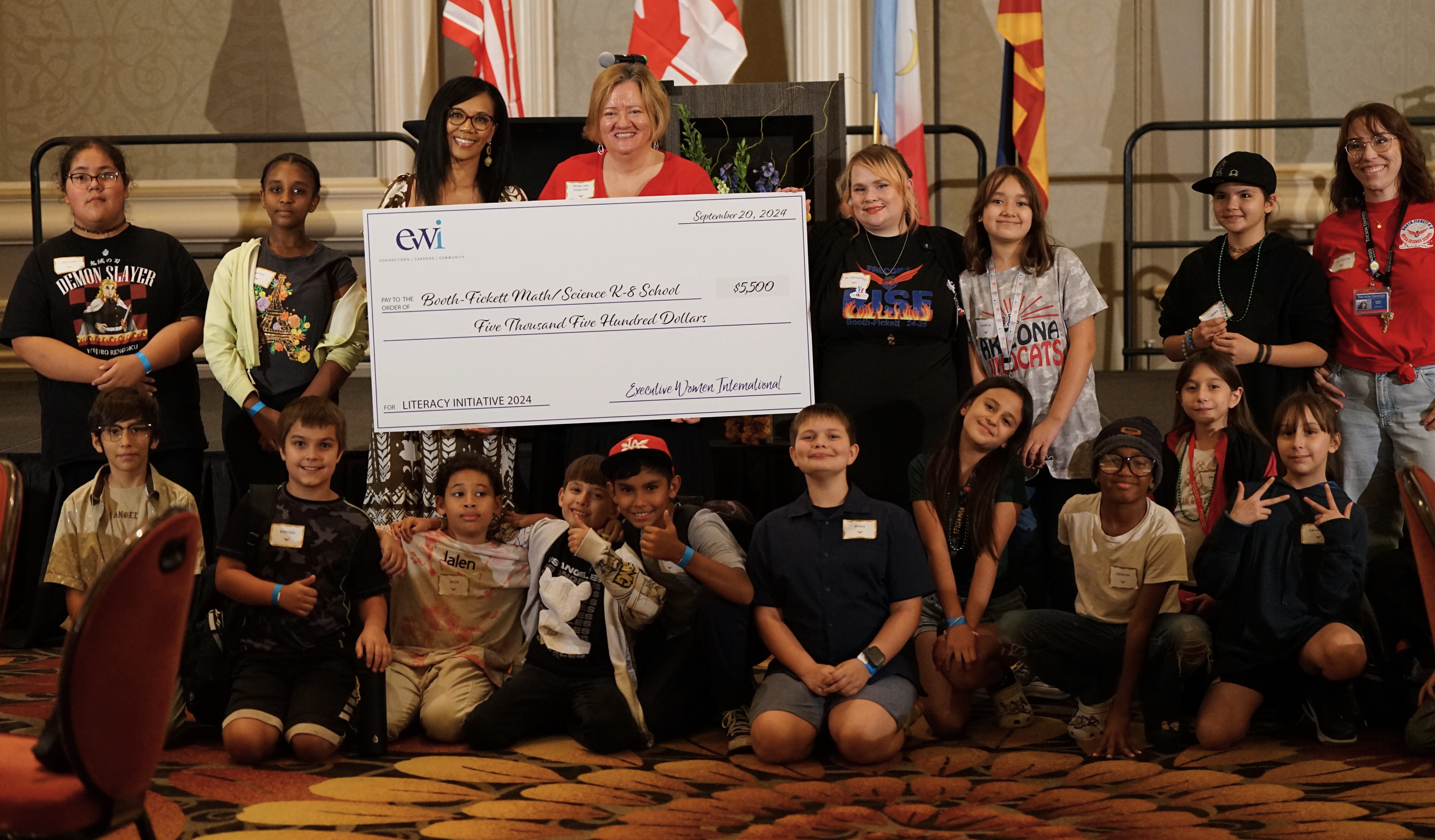 Booth Fickett's staff and students pose with their giant check