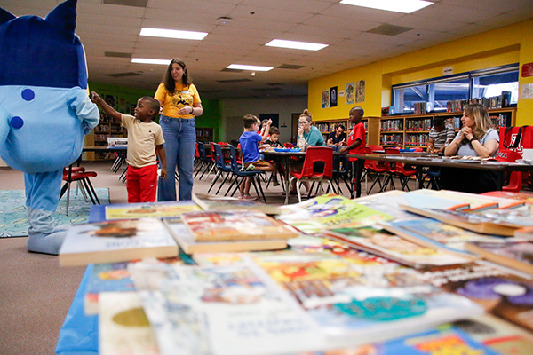 A little boy says hi to Bluey during Literacy Night