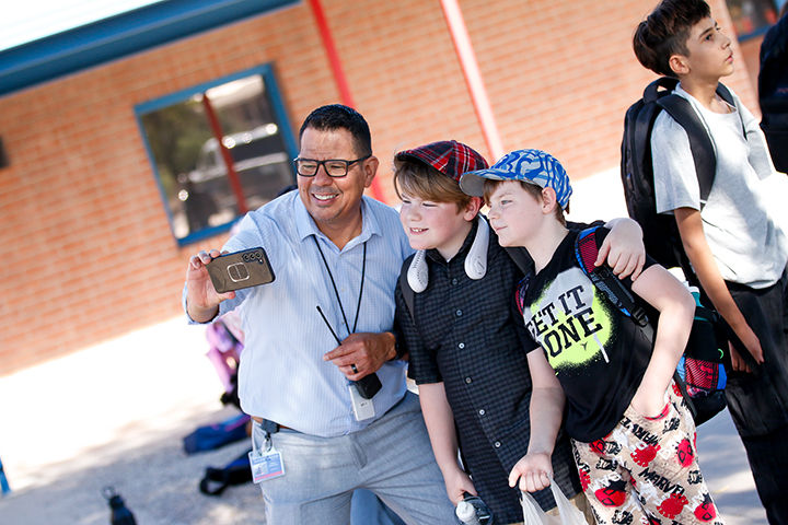 A man in glasses takes a selfie with two boys