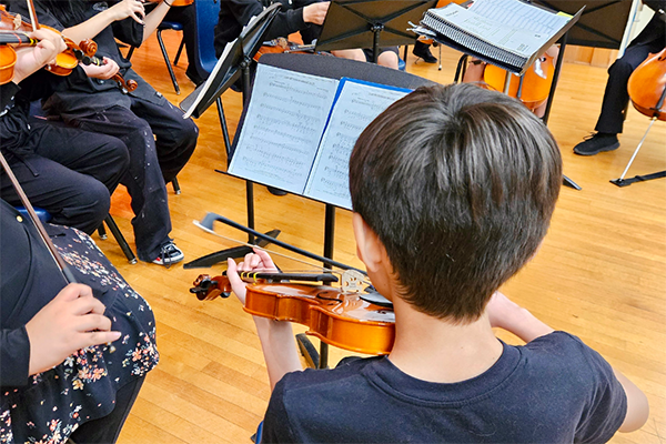 A boy plays violin on stage