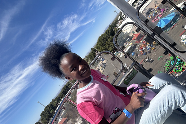 A girl smiles as she rides in the ferris wheel