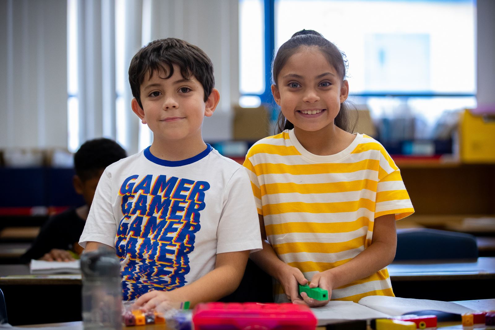 Students smile while building with blocks during the first week of school